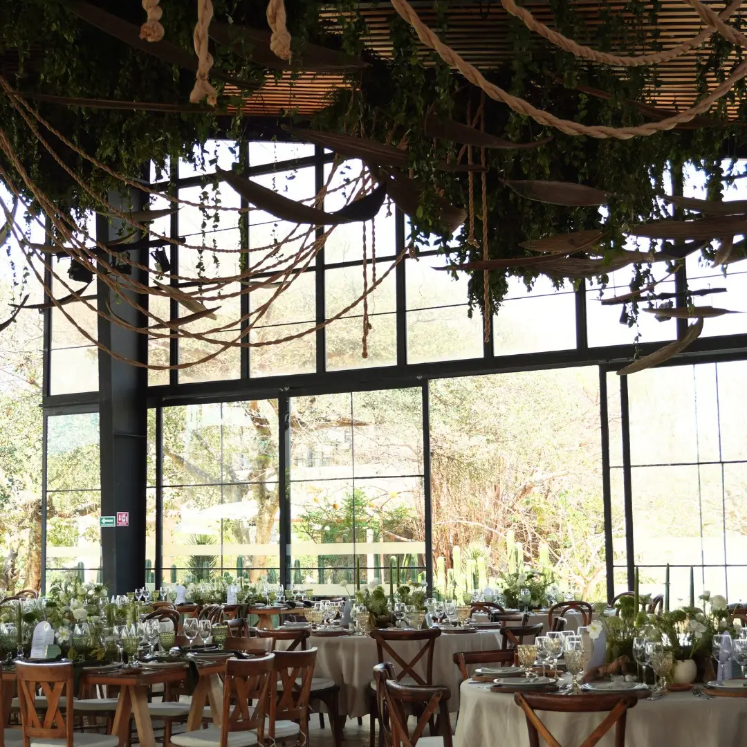 Recepción de boda en un jardín iluminado al atardecer.